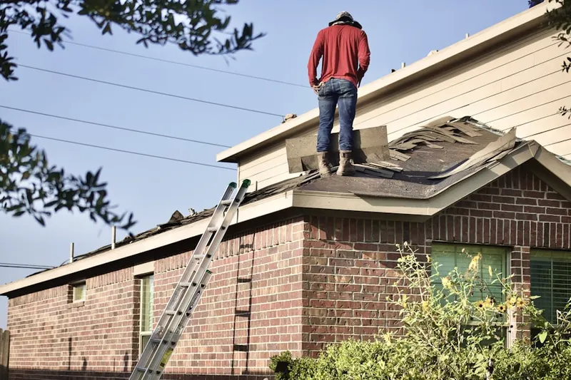 Professional roofer working on a residential roof in Haskell